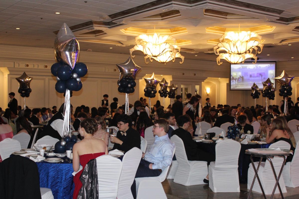  A special group of friends pose while eating on prom night, sharing their meal together before they get ready to dance.